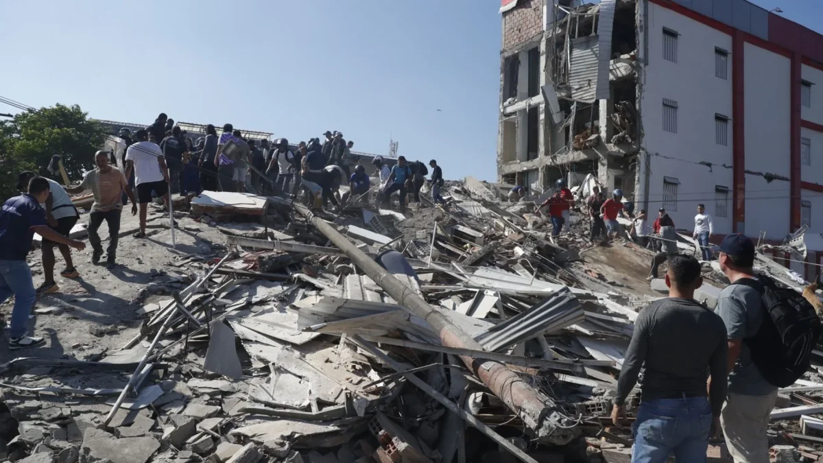 Personas caminan sobre los escombros de un edificio colapsado este lunes, en Cali (Colombia).