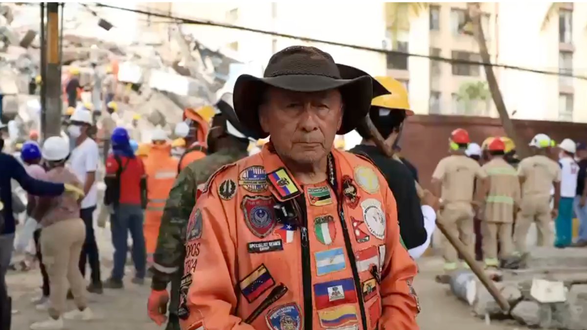 Un rescatista de Topos Azteca explica las posiciones de seguridad durante un terremoto, mientras equipos trabajan entre los escombros.