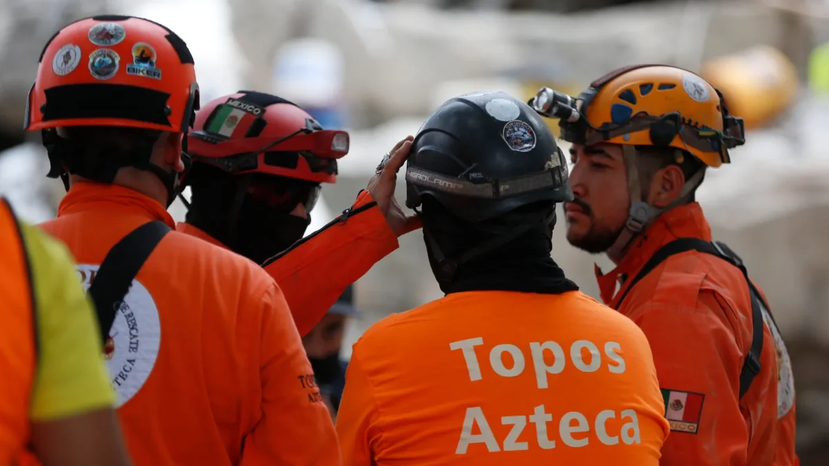 Integrantes de una brigada de Los Topos Aztecas mexicanos habla este miércoles, durante una jornada de búsqueda y rescate en Cali (Colombia).