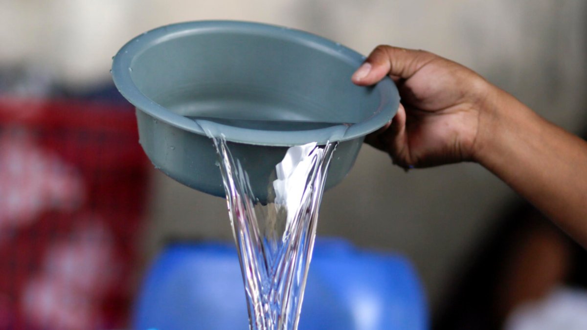 El hondureño Darwin Ordoñez llena un recipiente con agua este 14 de agosto de 2026, en Tegucigalpa (Honduras).