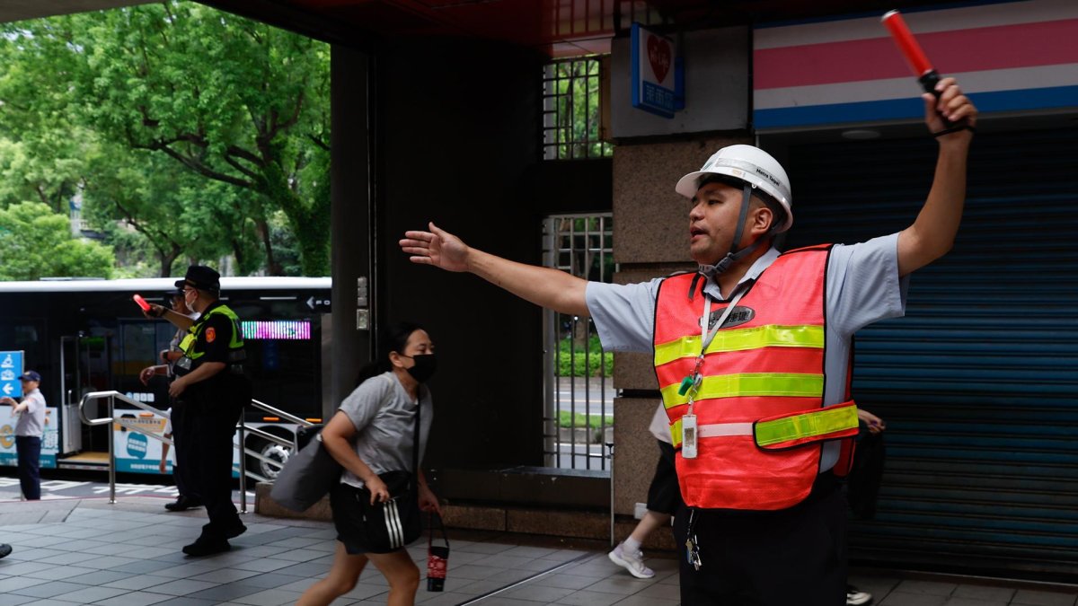 Personal de seguridad guía a las personas para que se refugien dentro de una estación de metro durante el simulacro de ataque aéreo de Wan-An o simulacro urbano, el 13 de agosto de 2026.