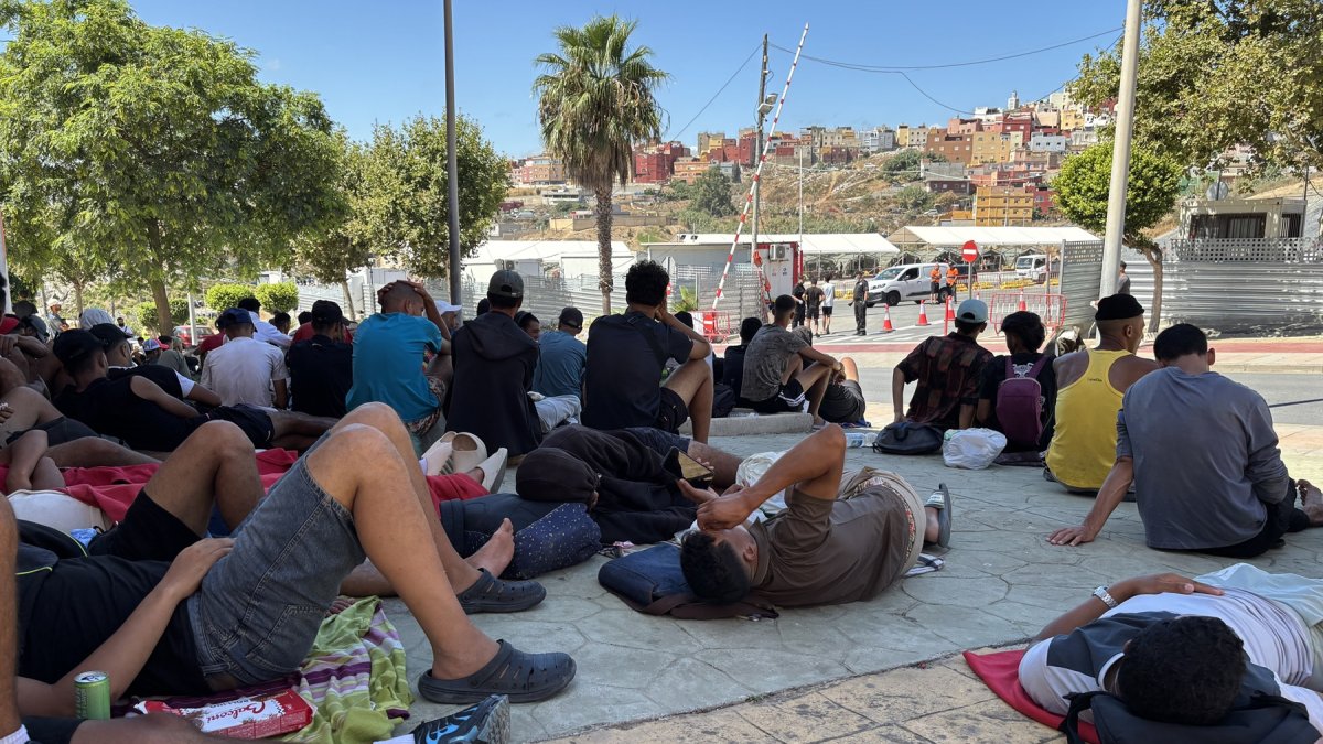 Varios migrantes congregados en los alrededores del Embolsamiento Loma Colmenar, uno de los puntos de acogida, este sábado 22 de agosto en Ceuta.