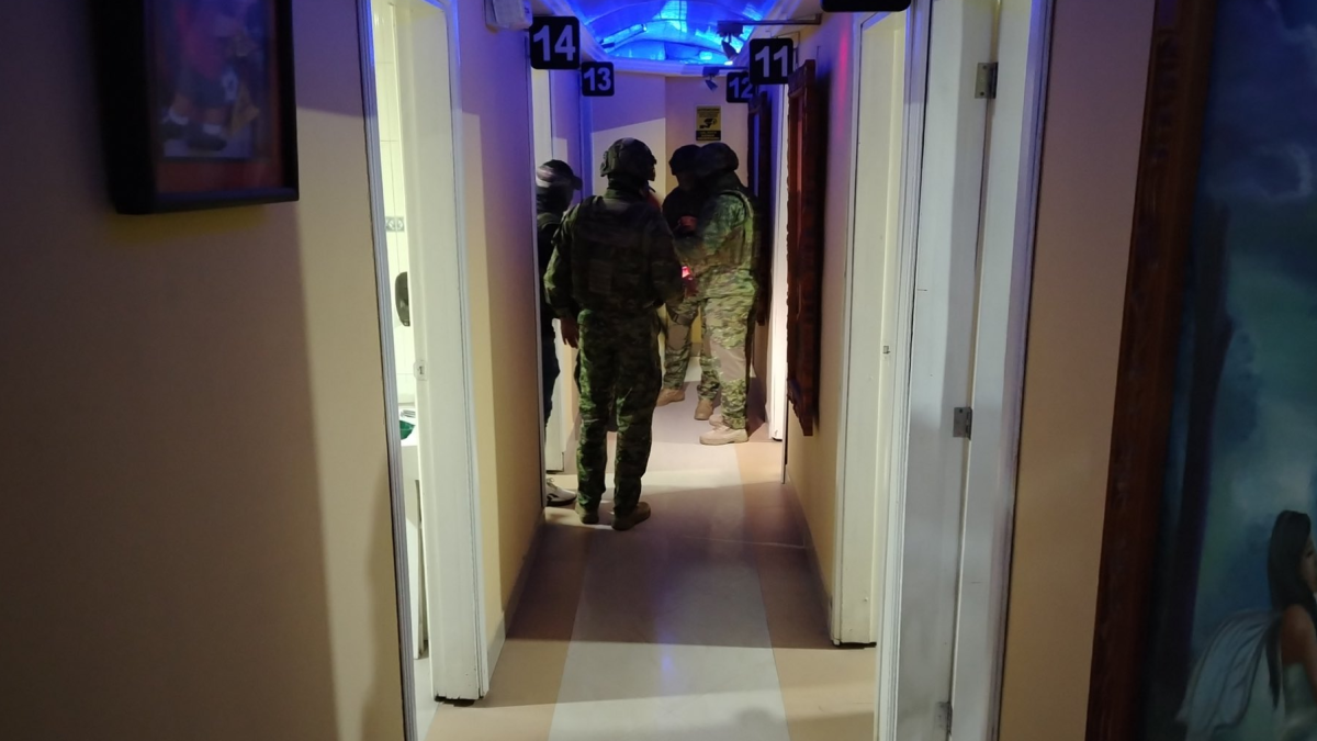 Agentes policiales inspeccionan el interior del night club en Cuenca, donde se halló una caleta con dinero oculto.