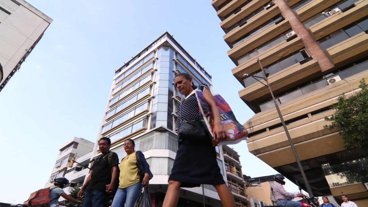 Ciudadanos caminan por la intersección de las calles Lorenzo de Garaycoa y Clemente Ballén, en el centro de Guayaquil, rodeados por edificios.