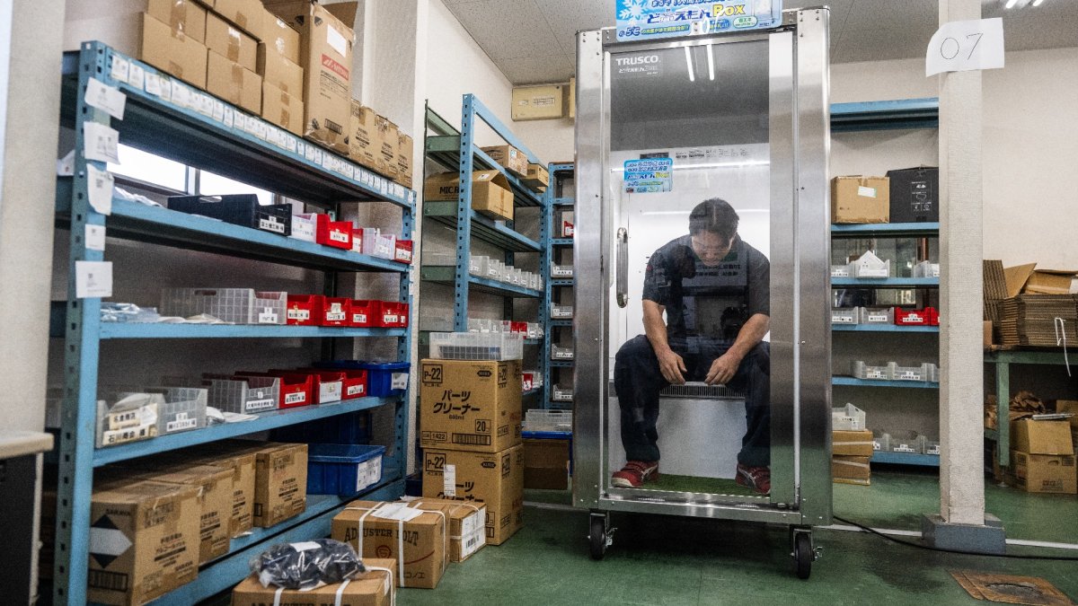Taichi Konishi, empleado de Konoe, descansa en una cabina de refrigeración para trabajadores, en el almacén de la empresa, en un día caluroso en Higashiosaka, prefectura de Osaka.