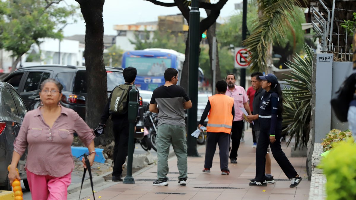 En Urdesa se pueden encontrar personas cuidan carros junto a los parquímetros.