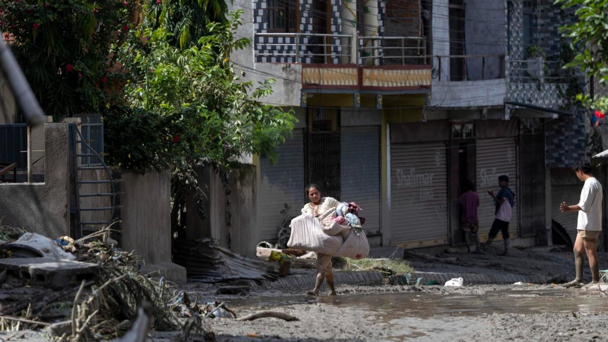 Los supervivientes de las inundaciones regresan a sus hogares tras una crecida repentina en la aldea de Devighat, distrito de Nuwakot, Nepal, el 27 de agosto de 2026.