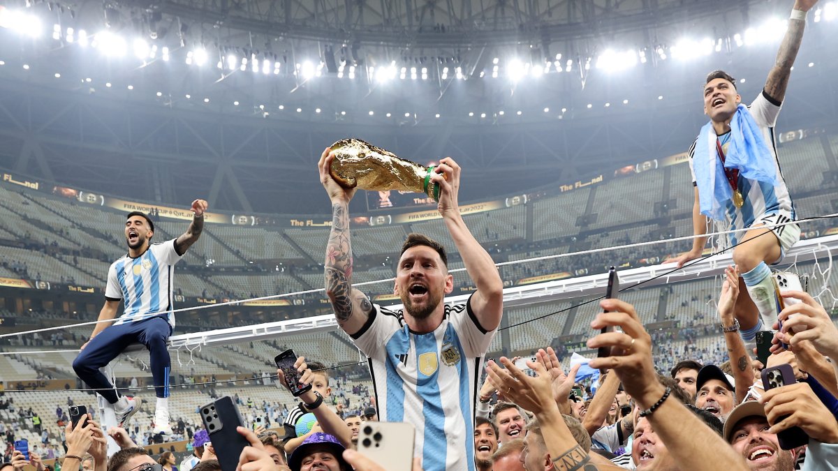 Lionel Messi (c) alza el trofeo del campeones del Mundial de Qatar 2022.