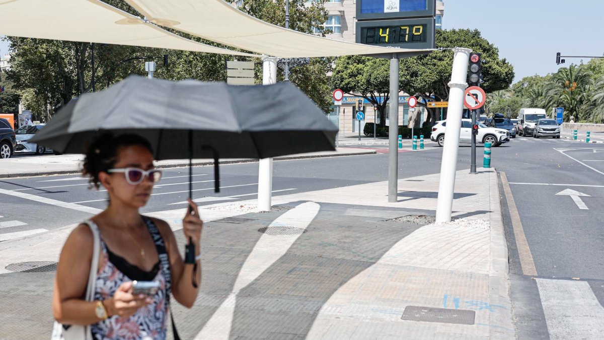 Una mujer se protege con un paraguas del intenso sol el 19 de agosto de 2026 en la plaza América de Valencia.