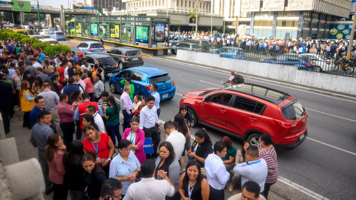 Foto referencial: Empleados de oficina permanecen fuera de los edificios tras la evacuación provocada por el fuerte terremoto que sacudió la Ciudad de Guatemala el 8 de julio de 2025.