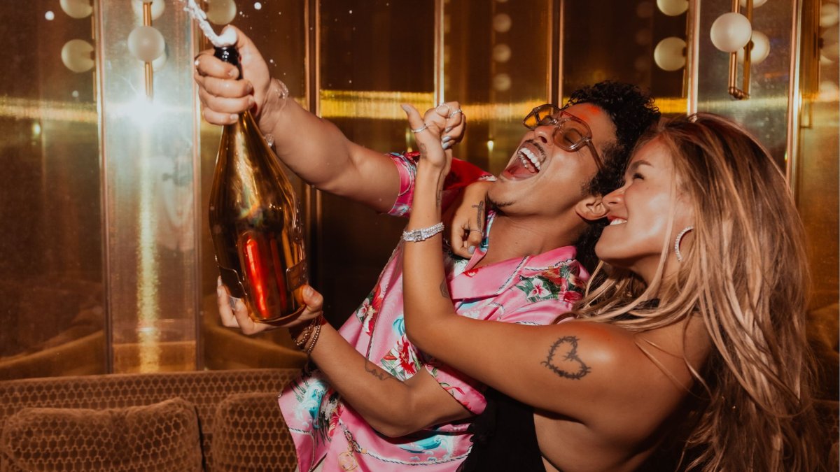 Bruno Mars y Karol G celebrando el éxito de su nueva canción.