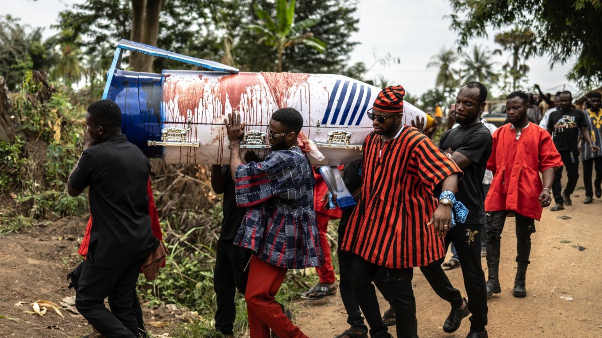Los familiares llevan el ataúd en forma de bolígrafo manchado de sangre de oveja del difunto maestro ghanés Samuel Commey Tetteh, el 15 de agosto de 2026.