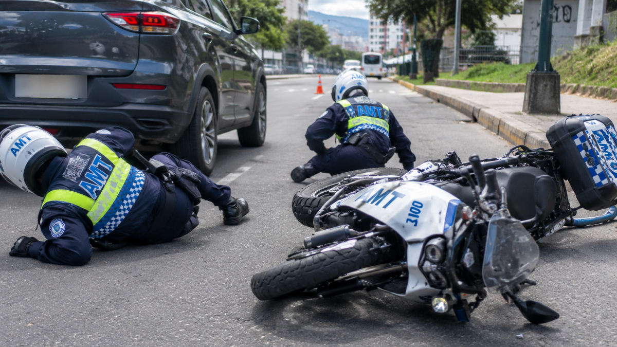 Referencia. Dos agentes civiles de tránsito cayeron luego de que un conductor embistiera una motocicleta institucional de la AMT en Quito.
