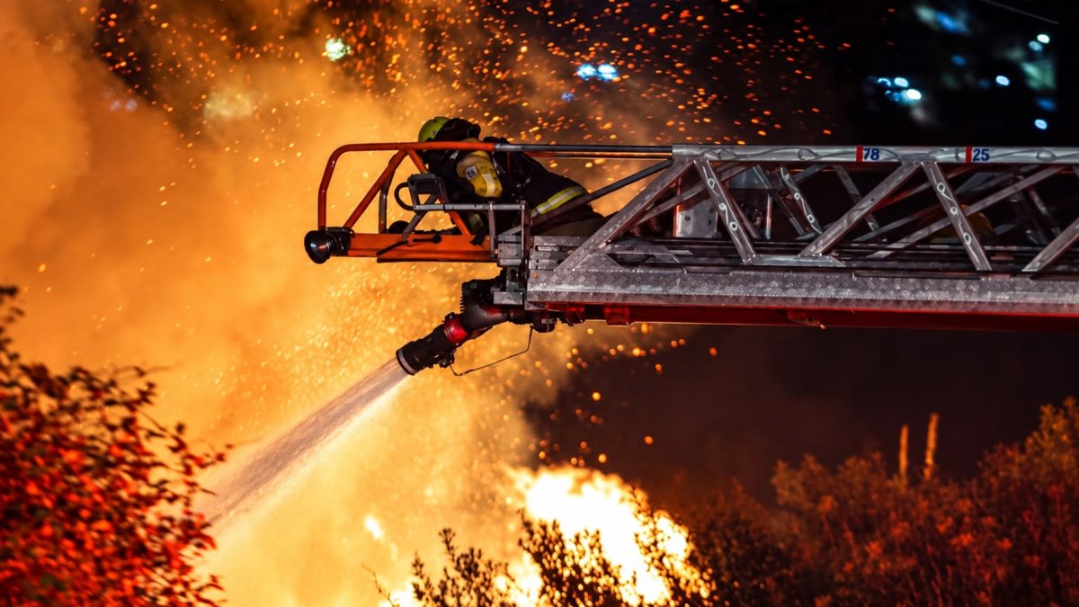 Personal bomberil intenta sofocar las llamas en el sector de La Vicentina, cerca de la avenida Velasco Ibarra, en Quito, la noche de este miércoles 16 de septiembre.