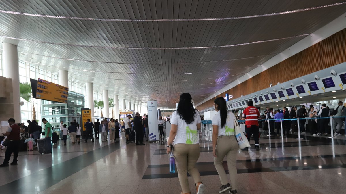 VISTA DE PASAJEROS CAMINANDO POR LOS PASILLOS DE LA TERMINAL AÉREA ||