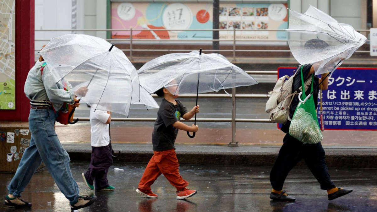 Personas se cubren de las lluvias causadas por el tifón Dujuan en Tokio, Japón.