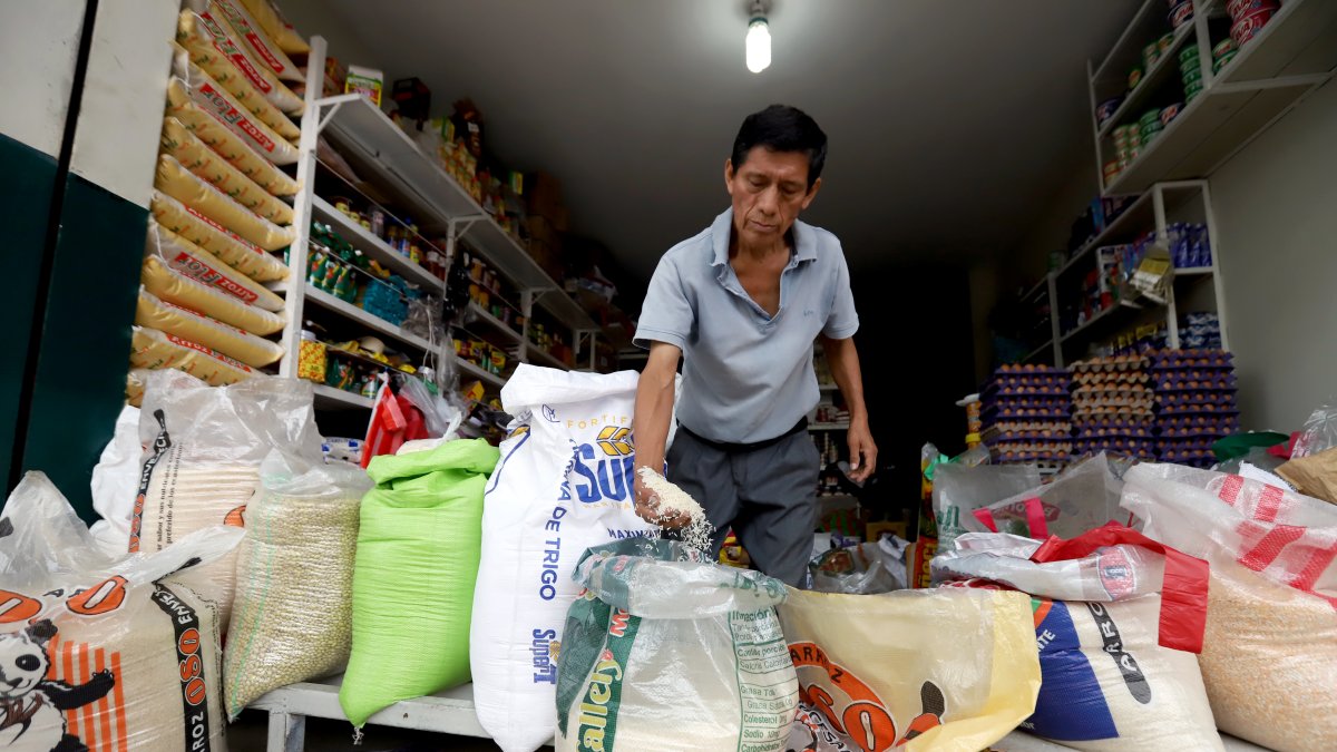 Un comerciante muestra que el arroz de grano largo es de mejor calidad y que la libra cuesta 0,50 dólares.