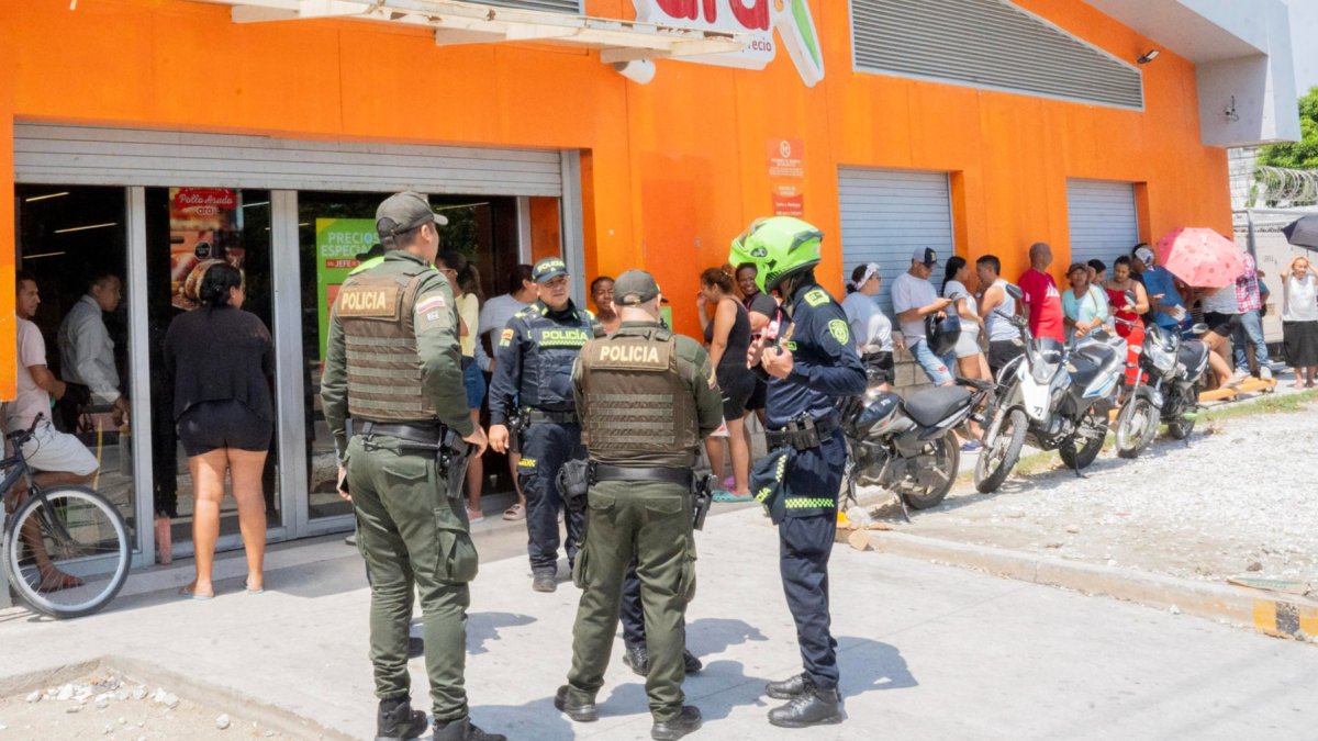 Integrantes de la Policía de Colombia custodian un negocio tras la violencia desatada por las paramilitares ACSN en Santa Marta (Colombia).