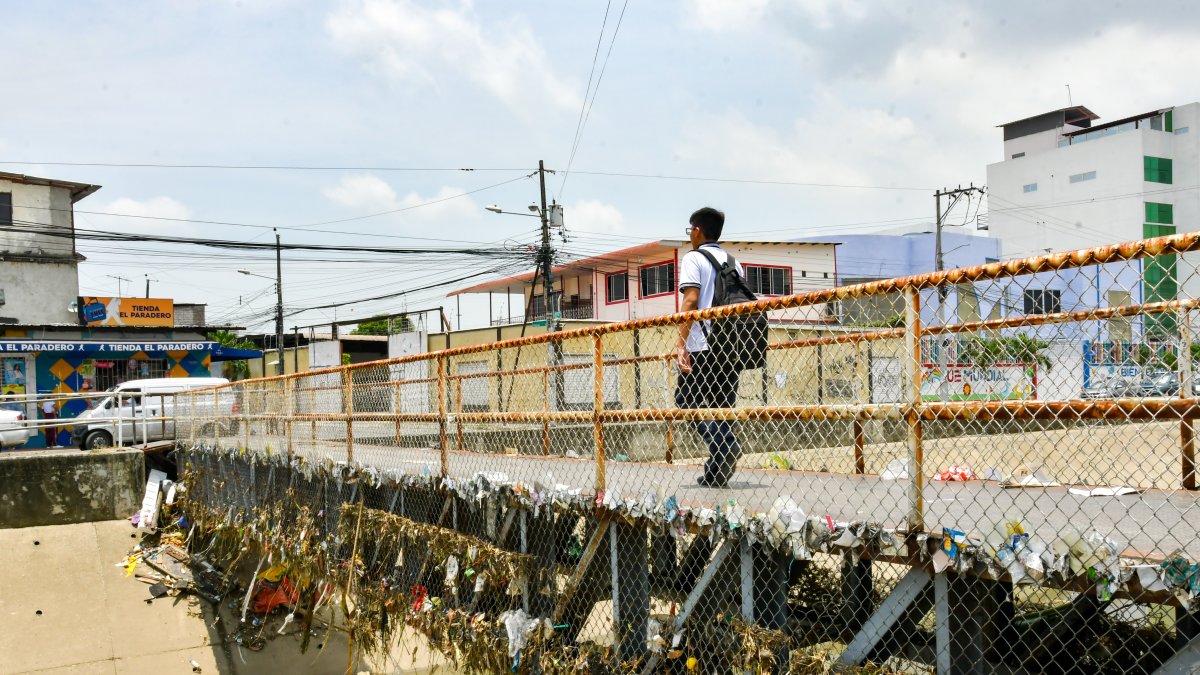 Basura enredada en paso peatonal del canal de Las Orquídeas
