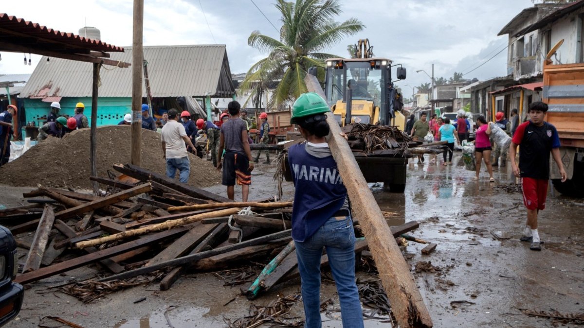 Un miembro de la Marina de México transporta una viga de madera durante la emergencia causada por el huracán Polo en Playa Azul, México, el 24 de septiembre de 2026.