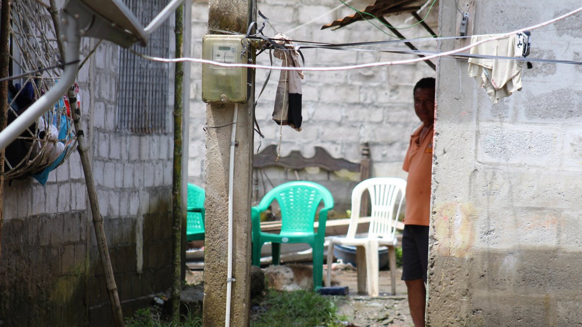 Un morador permanece dentro de su vivienda, rodeado por el agua acumulada tras las fuertes lluvias que afectaron a La Unión, en Quinindé.