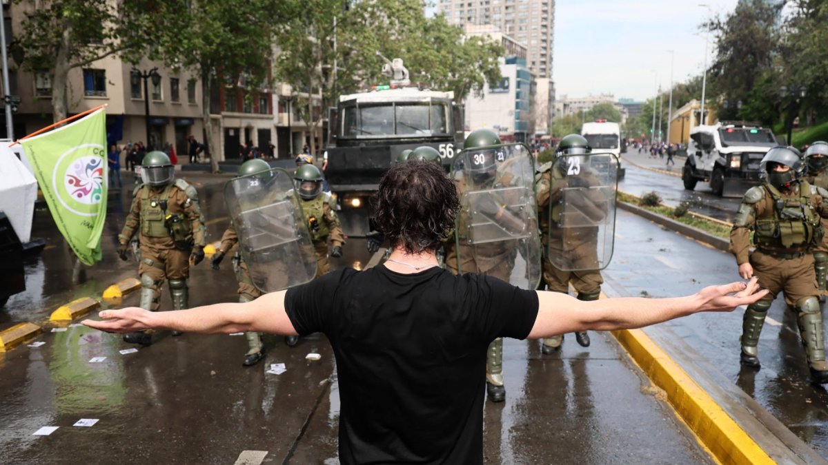 Carabineros de Chile y un manifestante se enfrentan durante la movilización nacional convocada por la Confederación de Estudiantes de Chile.