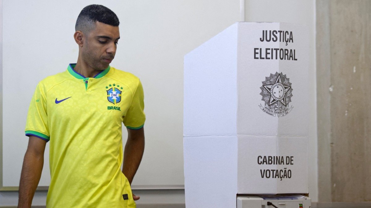 Un votante que lleva la camiseta de la selección nacional de fútbol de Brasil sufraga en un centro electoral en Brasilia, este domingo 4 de octubre de 2026.