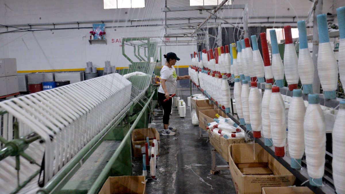 Una persona realiza su trabajo en una industria de textil, en Quito.