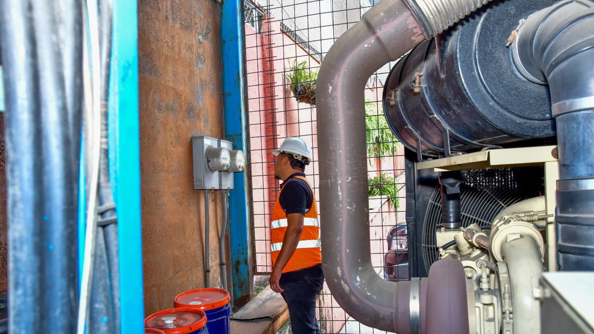 Un trabajador revisa los medidores de energía eléctrica en una empresa, en Guayaquil.