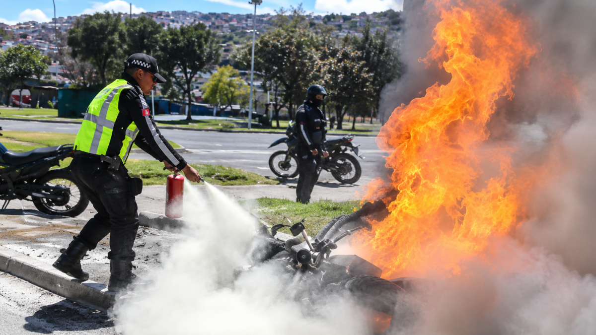 Una motocicleta se incendió durante un operativo de tránsito en Guajaló, al sur de Quito. Un agente de la AMT logró apagar las llamas.