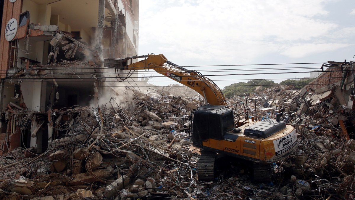 Fotografía que muestra una retroexcavadora durante el proceso de demolición de edificios afectados por el terremoto en Cali.