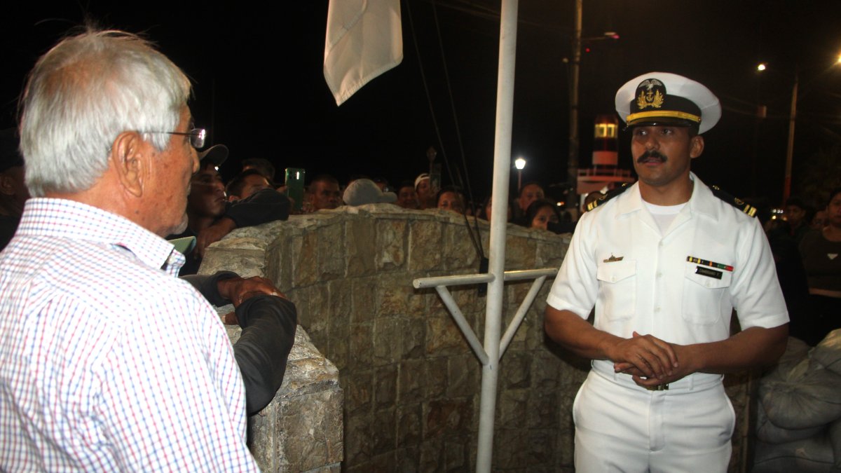 Un oficial de la Armada del Ecuador explica a los familaires de las labores de búsqueda de los pescadores desaparecidos