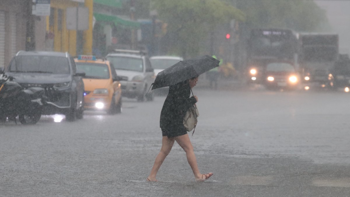 Paraguas en mano, un ciudadano camina bajo la intensa lluvia que sorprendió a Guayaquil este lunes 19 de octubre y complicó las actividades cotidianas en distintos sectores de la ciudad.