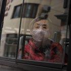 Una mujer que llevaba una máscara facial viaja en un autobús en Shangai el 2 de marzo de 2020. El número global de muertos por la nueva epidemia de coronavirus superó los 3.000