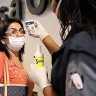 Funcionarios toman la temperatura de los ciudadanos que llegan al aeropuerto internacional El Dorado, el jueves 5 de marzo de 2020, en Bogotá (Colombia). El Ministerio de Salud de Colombia confirmó este viernes el primer caso de coronavirus en el país, una paciente que está internada en una clínica de Bogotá donde fue diagnosticada con el COVID-19. EFE/ Carlos Ortega COLOMBIA CORONAVIRUS