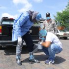 Personas, en el exterior del hospital del Guasmo Sur, usan cinta como medida de protección.