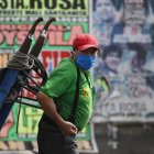 Un hombre con tapabocas trabaja en el Mercado Mayorista de Frutas de Lima (Perú). Casi sin recursos y sin otras opciones, Perú comenzará formalmente a reabrir su cuarentena.