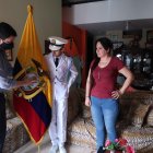 Anthony Santillán Mora, abanderado de la Academia Naval Guayaquil, recibe en su casa la bandera por parte de un directivo de la plantel. A su lado está su mamá.