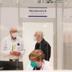 El alcalde de Hamburgo, Peter Tschentscher (d) habla con el director médico del centro de vacunación de la ciudad, Dirk Heinrich (i), sobre el inicio de la campaña de inmuinización.