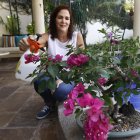 Patricia March de 50 años de edad, riega sus plantas en el jardín de su casa.