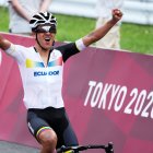 Richard Carapaz levanta los brazos unos metros antes de cruzar la meta para ganar el oro olímpico.