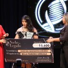 Bella Paredes recibiendo de manos de la prefecta Susana González el primero al Legado de Oro y dinero en efectivo.