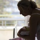 Costumbre. Una madre arrulla a un recién nacido al pie de su cuna.