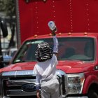 San Salvador. Un menor traslada mercadería entre los vehículos estacionados en una esquina de esta capital centroamericana.