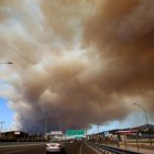 Un espeso humo cubre la carretera nacional en Atenas debido a un incendio forestal que estalló en una zona de tierras de cultivo y bosque en Varnavas, región de Ática, Grecia.