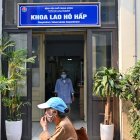 Una mujer caminando frente a la entrada del departamento de tuberculosis respiratoria del Hospital Nacional del Pulmón en Hanoi.
