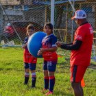 Marlon Ayoví (d) entrena a niños en los vacacionales del club Ferrocarril Oeste