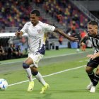 El extremo Bryan Ramírez intenta evadir la férrea marca del lateral Braian Cutré.