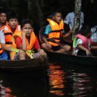 Un grupo de niños en canoas dirigiéndose a un vivero por el rio Itaya, en Iquitos (Perú).