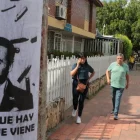 Personas caminan junto a un cartel alusivo al ultraderechista Abelardo de la Espriella.